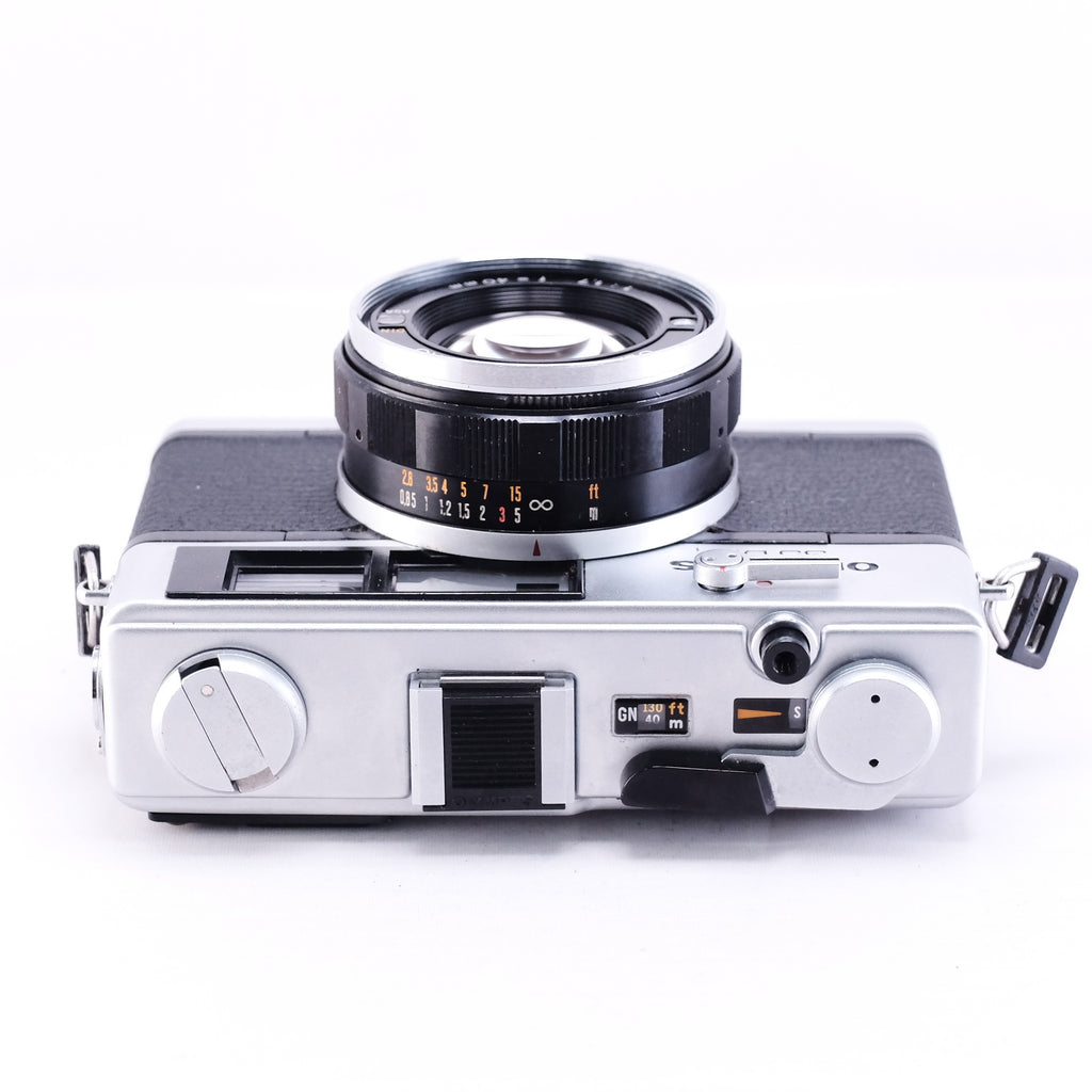 OLYMPUS 35DC film camera in black, top view with lens, vintage design and rangefinder features.